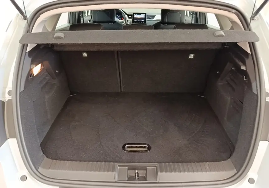 Vue arrière du coffre ouvert d’un Renault Captur gris clair, montrant l’espace de chargement et la tablette cache-bagages.