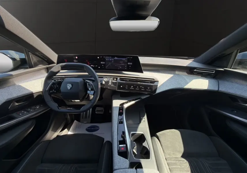Vue intérieure avant du Peugeot 5008 2025 avec sellerie alcantara noire et tableau de bord numérique panoramique.