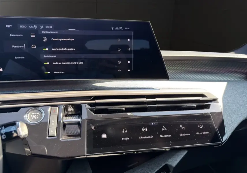 Tableau de bord du Peugeot 5008 2025 avec écran tactile central et commandes numériques en finition noire brillante.