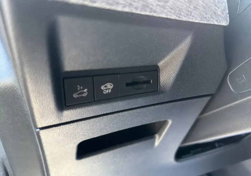 Gros plan sur les commandes noires d'ouverture et désactivation du hayon dans l'habitacle du Peugeot 5008 noir.
