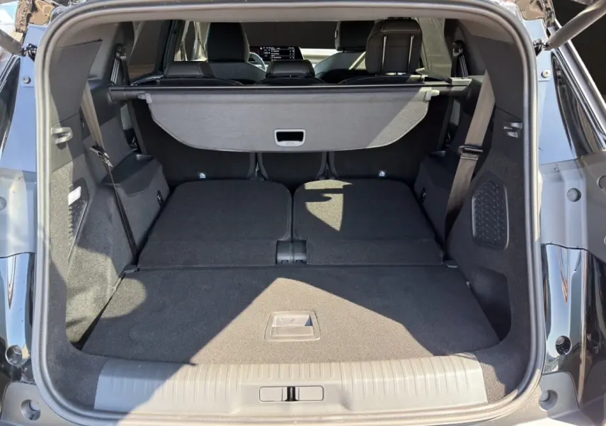 Coffre ouvert d’un Peugeot 5008 noir, vue arrière montrant les sièges rabattus et la tablette de coffre.