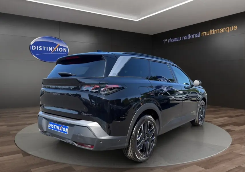 Peugeot 5008 noir vue 3/4 arrière droit, jantes noires, vitres teintées et toit avec rails assortis.