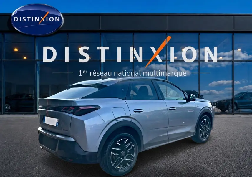 Peugeot 3008 gris 3/4 arrière droit, avec jantes alu noires et feux arrière LED distinctifs, devant vitrine Distinxion.