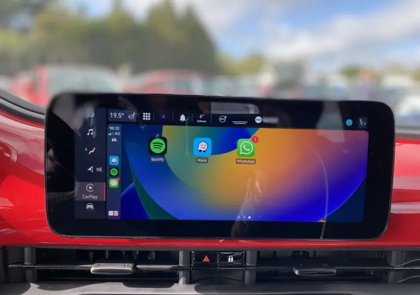 Écran tactile central affichant Spotify, Waze et WhatsApp sur tableau de bord rouge d'une Fiat 500 Cabriolet Electrique 2022.