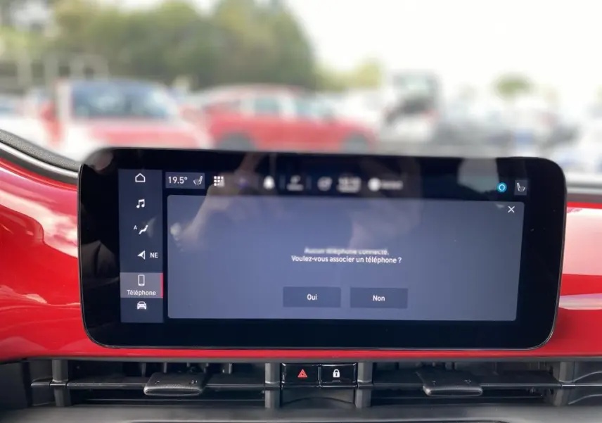 Écran tactile central du tableau de bord rouge d'une Fiat 500 Cabriolet Electrique 2022 affichant une demande d'association téléphonique.