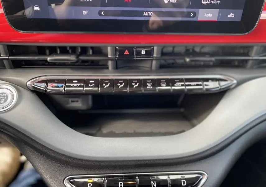 Vue rapprochée de la console centrale rouge d'une Fiat 500 Cabriolet électrique 2022 avec commandes climatisation et boîte auto.