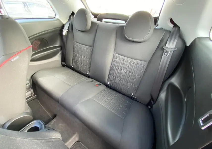 Banquette arrière noire avec motifs FIAT embossés, vue intérieure côté droit du Fiat 500 Cabriolet Electrique rouge.