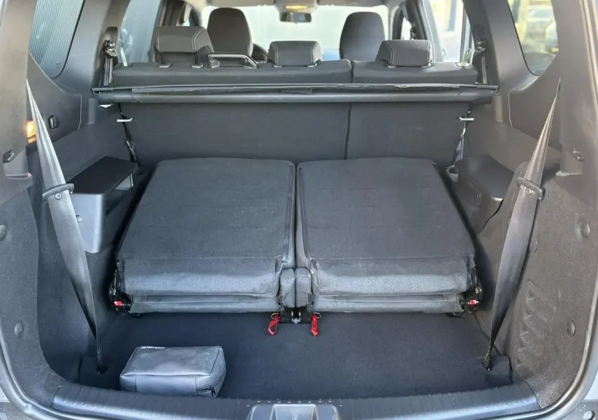 Vue arrière du coffre du Dacia Jogger gris avec sièges rabattus et espace de chargement dégagé.