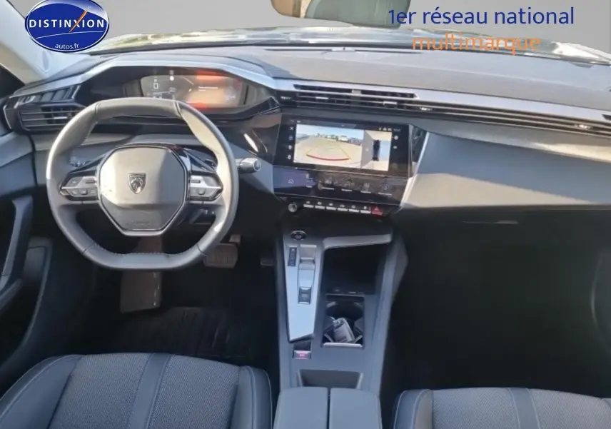 Vue intérieure avant du Peugeot 408 Hybrid 145 allure e-dcs6 noir, avec volant cuir et écran tactile affichant la caméra de recul.