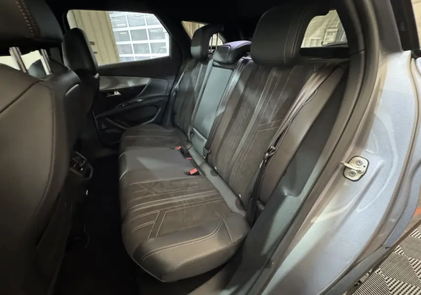 Vue intérieure côté droit montrant la banquette arrière en cuir noir du Peugeot 3008 gris clair 2021.