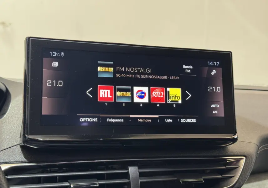 Écran tactile central de 10 pouces affichant les stations radio dans l’habitacle d’une Peugeot 3008 gris clair.