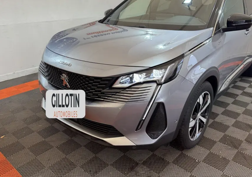 Vue 3/4 avant droit d’un Peugeot 3008 gris clair avec calandre noire et phares LED distinctifs.
