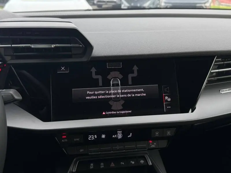 Vue rapprochée de l’écran central et de la console de l’Audi A3 Sportback 2024 avec affichage d’aide au stationnement.