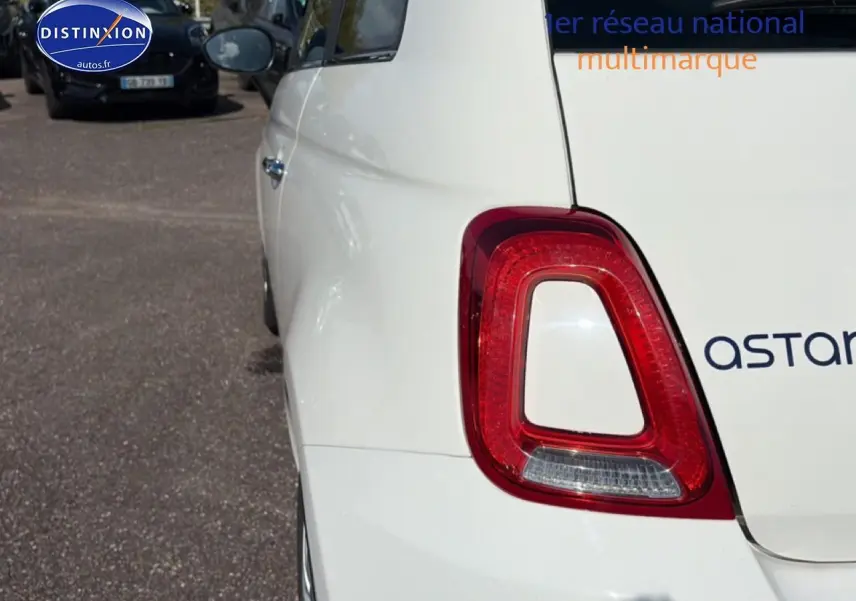Vue arrière côté gauche d'une FIAT 500 blanche 2023 avec feu arrière rouge et vitre latérale teintée.