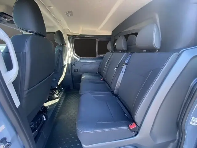 Vue intérieure côté droit sur la banquette arrière noire du Renault Trafic Fourgon gris foncé, avec ceinture de sécurité visible.