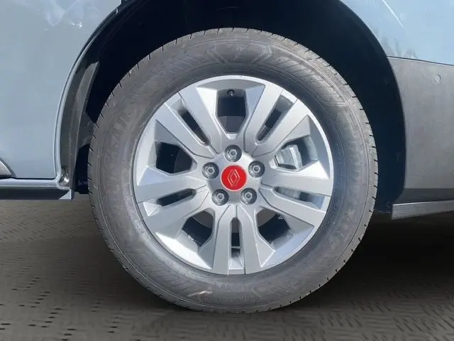 Gros plan sur la roue avant droite gris foncé du Renault Trafic Fourgon avec jante argentée et logo rouge au centre.
