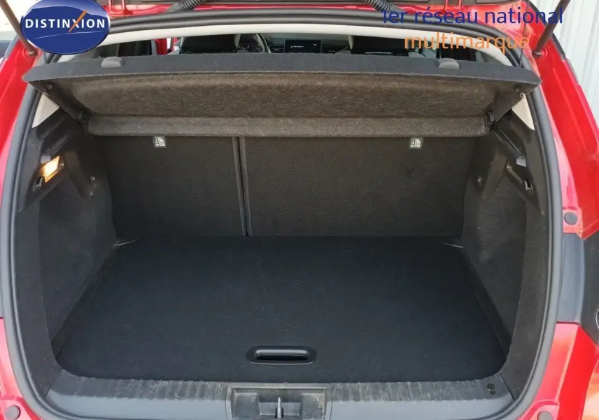 Coffre ouvert d’un Renault Captur TCE90 Intens rouge toit noir, vue arrière montrant l’espace de chargement vide.