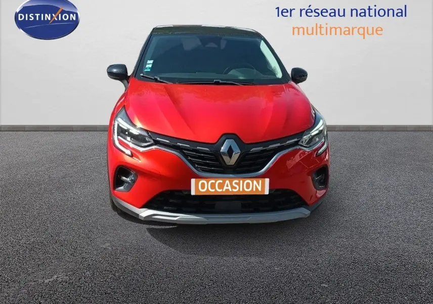Vue avant d'un Renault Captur TCe90 Intens rouge avec toit noir, calandre chromée et feux LED allumés.