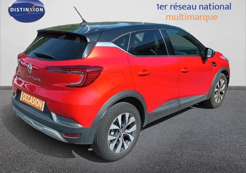 Vue 3/4 arrière droite d’un Renault Captur TCE90 Intens rouge avec toit noir et jantes alliage biton.