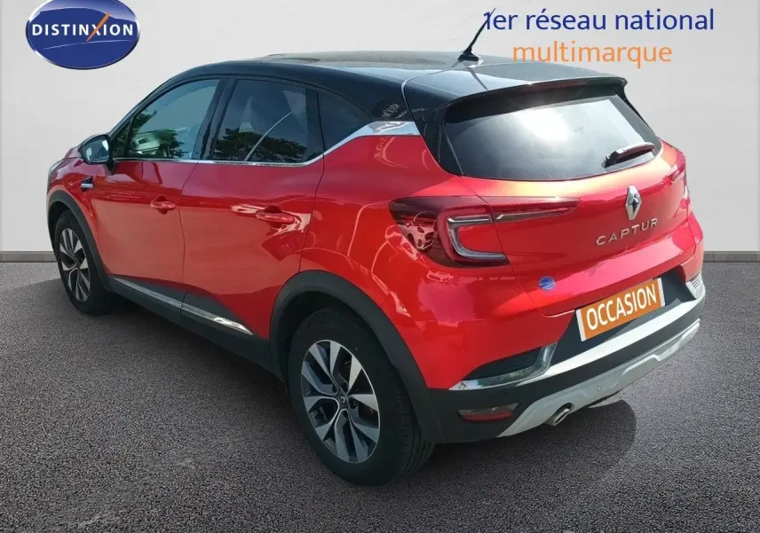 Vue 3/4 arrière droite d'un Renault Captur TCE90 Intens rouge avec toit noir et jantes alliage biton.