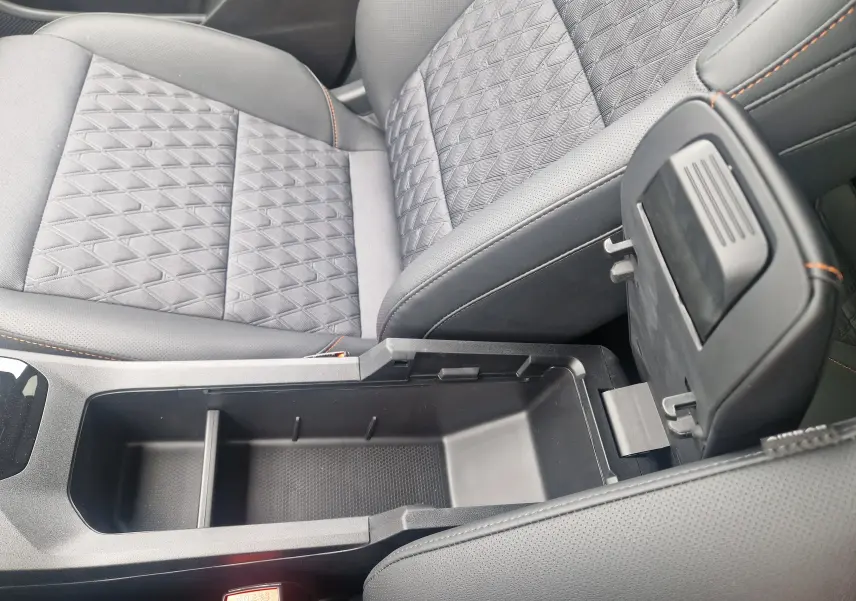 Vue rapprochée de la console centrale ouverte et siège avant en tissu noir avec surpiqûres orange dans MG3 Cosmic Silver 2026.