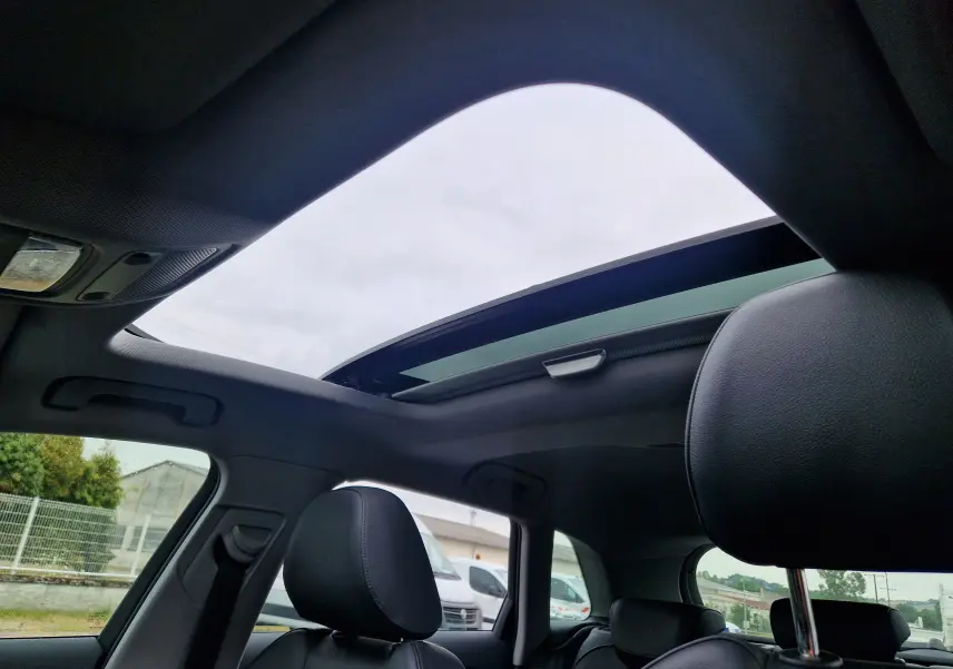 Vue intérieure de l'Audi A3 Sportback 2019 noire, mettant en valeur le toit ouvrant panoramique et les sièges en cuir noir.