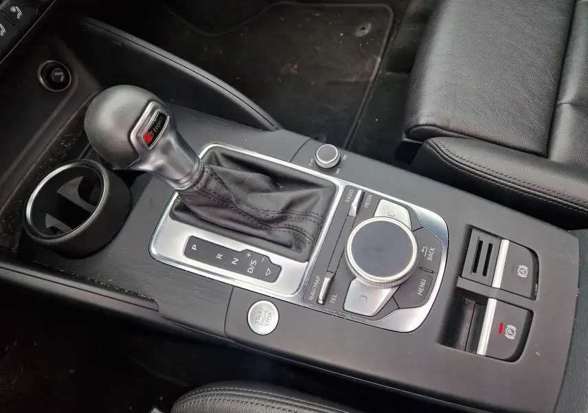 Vue rapprochée de la console centrale noire de l'Audi A3 Sportback 2019 avec levier de vitesse S-tronic et commandes multimédia.