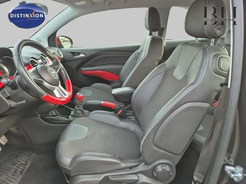 Vue intérieure côté gauche de l’Opel Adam Rocks noir avec sellerie cuir noire et accents rouges sur volant et levier de vitesse.