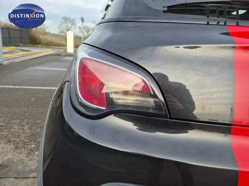 Gros plan sur le feu arrière gauche d’une Opel Adam Rocks noire avec bande rouge verticale sur le coffre.