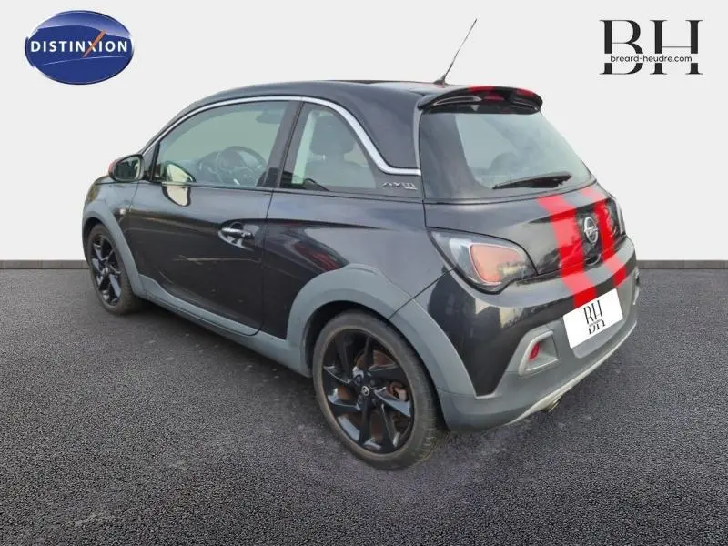 Vue 3/4 arrière droite d'une Opel Adam Rocks noire avec jantes noires et bandes rouges sur le coffre.
