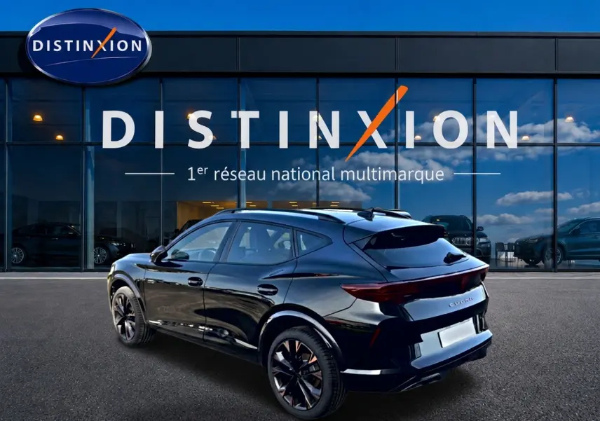 Vue 3/4 arrière droite d'un CUPRA Formentor noir brillant avec jantes 19 pouces devant une vitrine Distinxion.