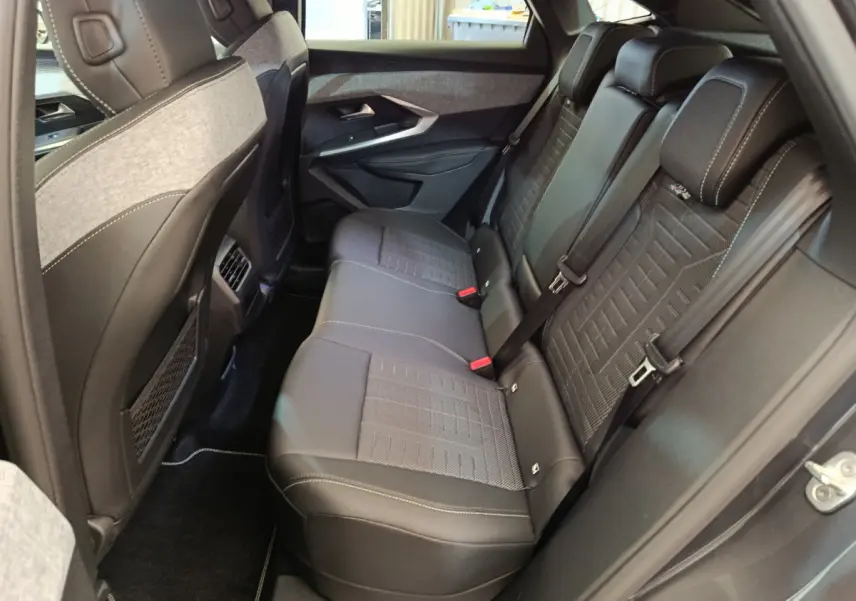 Vue intérieure côté droit montrant la banquette arrière en cuir noir et tissu gris du Peugeot 3008 1.2 Hybrid GT 2025.