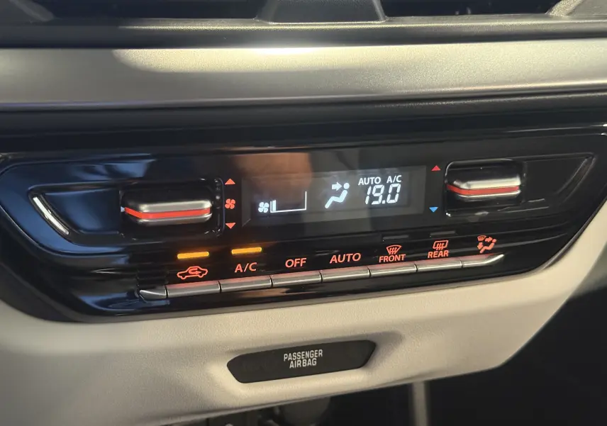 Panneau de commande de climatisation digital de la Suzuki Swift 2025 noire, affichant 19°C en mode automatique.