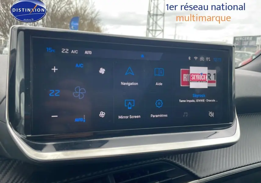 Écran tactile multifonction intérieur du Peugeot 2008 E-136 allure 2025 avec finition carbone et affichage climatisation.