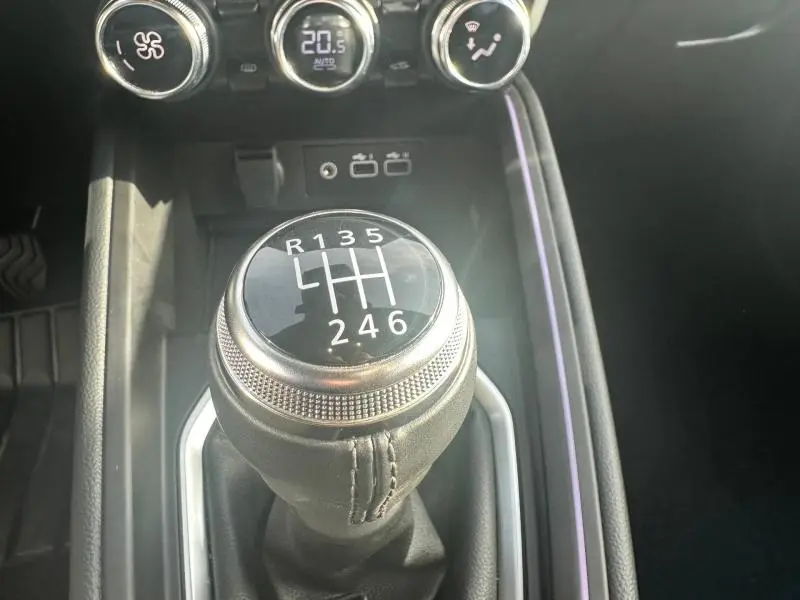 Gros plan sur le levier de vitesses manuel de la Renault Clio 1.0 TCe 90ch Techno 2025, avec commandes de climatisation en arrière-plan.