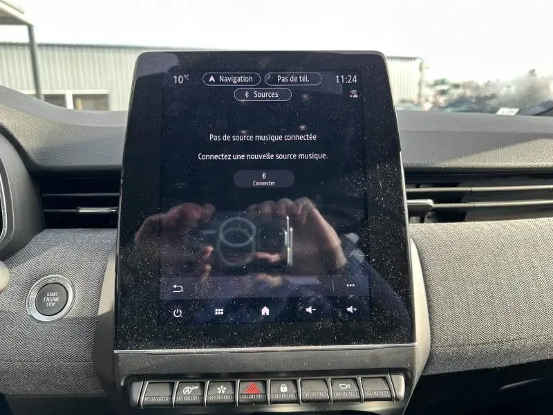 Écran tactile central de la Renault Clio 1.0 TCe 90ch Techno 2025 avec tableau de bord et bouton Start/Stop visibles.