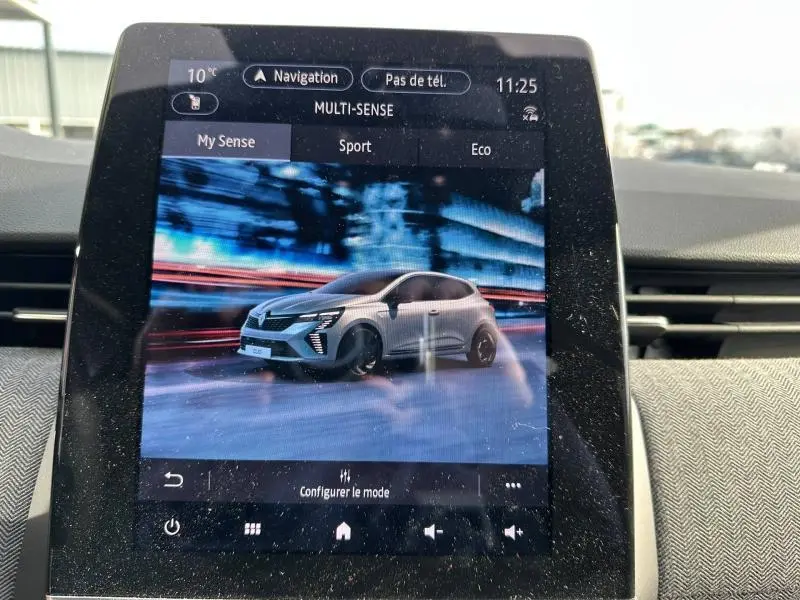 Écran tactile intérieur montrant une Renault Clio blanche en 3/4 avant dans le mode de conduite Multi-Sense.