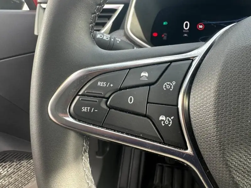 Gros plan sur les commandes au volant côté gauche de la Renault Clio 1.0 TCe 90ch Techno 2025, intérieur noir.