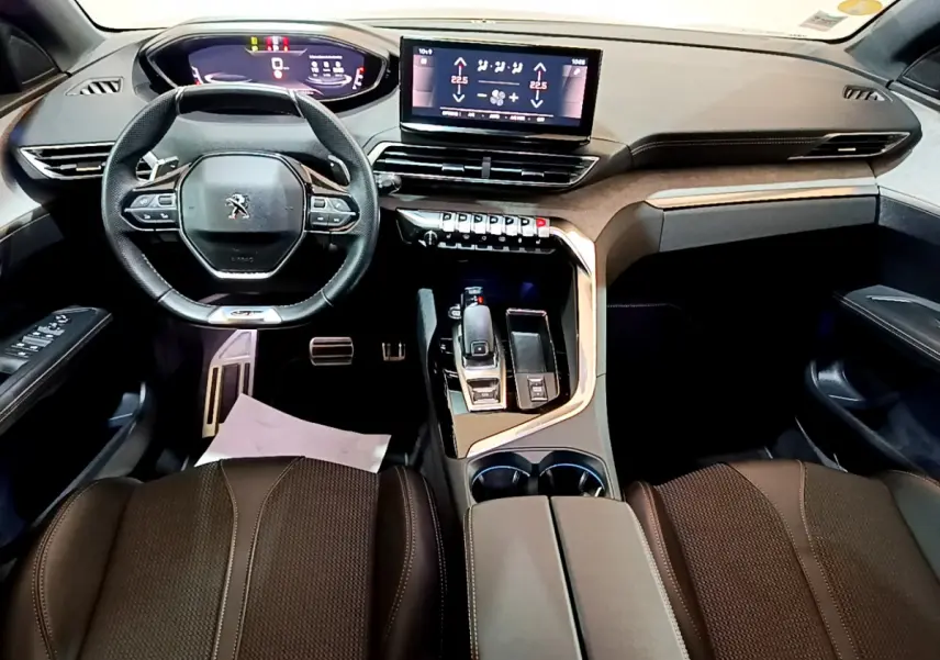 Vue intérieure avant du Peugeot 3008 GT 2023, tableau de bord moderne avec écran tactile central et volant cuir noir.