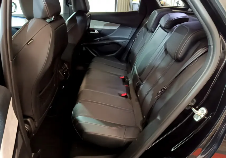 Vue intérieure côté droit des sièges arrière noirs en cuir du Peugeot 3008 GT 2023 avec surpiqûres contrastantes.