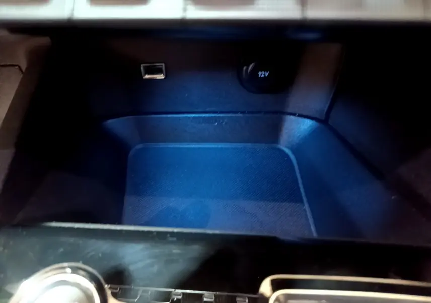 Gros plan sur la prise USB et la prise 12V dans le rangement central du Peugeot 3008 noir 2023.