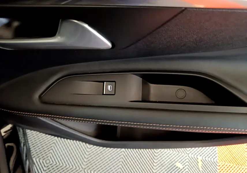 Gros plan sur la poignée intérieure côté gauche de porte noire avec surpiqûres orange du Peugeot 3008 GT 2023.