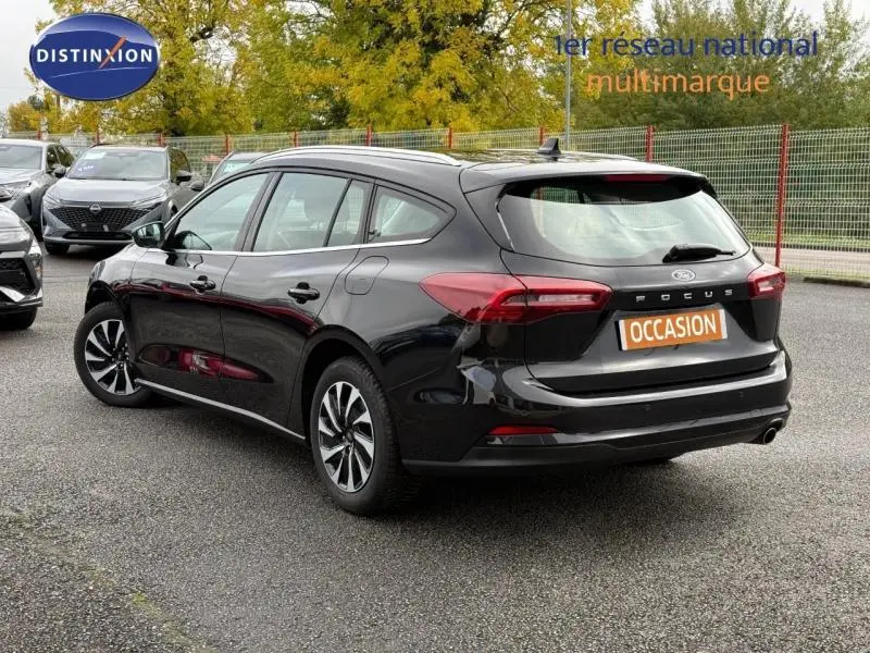 Vue 3/4 arrière droite d'une Ford Focus SW 2023 noire Agate métallisé avec badge Titanium et plaque occasion.
