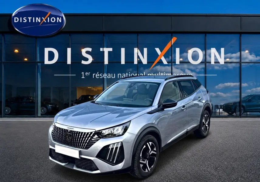 Peugeot 2008 gris artense en 3/4 avant droit devant une vitrine Distinxion, avec jantes alu et feux LED distinctifs.