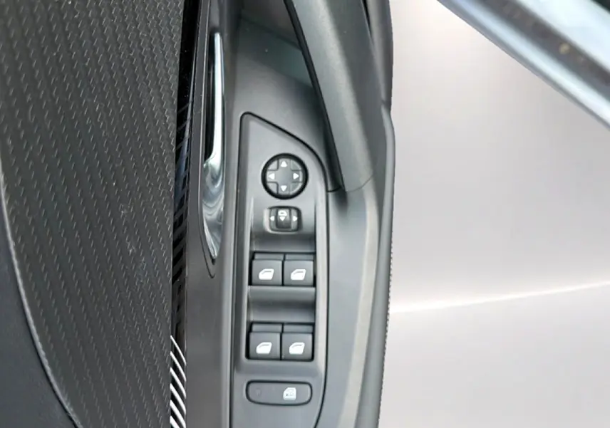 Vue rapprochée des commandes de lève-vitres et rétroviseurs côté conducteur du Peugeot 2008 gris Artense.