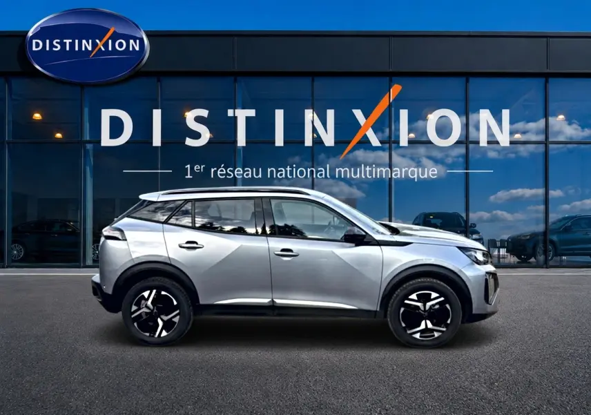 Peugeot 2008 gris artense vue de profil côté gauche devant une vitrine avec logo Distinxion.