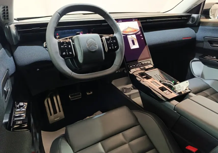 Vue intérieure avant du Citroën C5 Hybride 2026, volant cuir, tableau de bord numérique et écran tactile vertical.