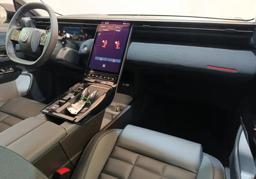 Intérieur avant de la Citroën C5 Hybride 2026, tableau de bord et console centrale avec grand écran tactile vertical.