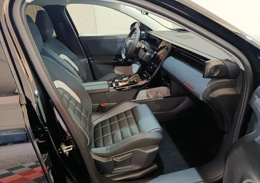Vue intérieure côté conducteur de la Citroën C5 Hybride 2026, sièges cuir noirs et tableau de bord avec écran tactile vertical.