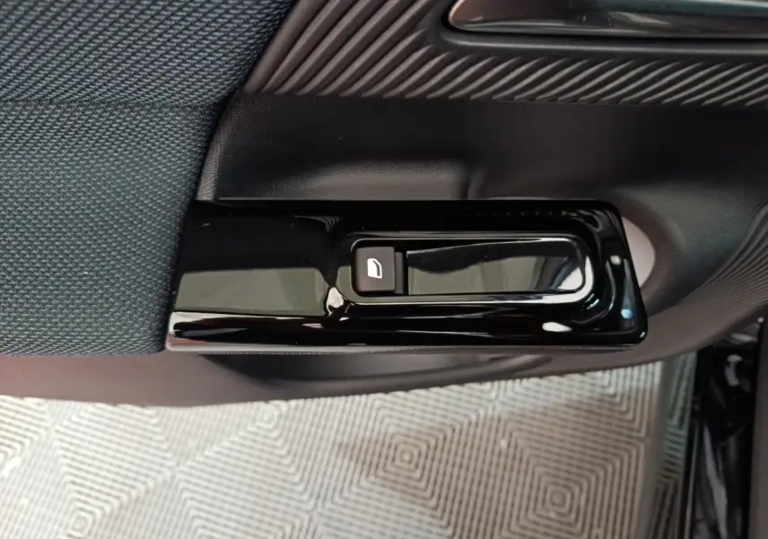 Gros plan sur le bouton de verrouillage de porte noir brillant côté intérieur d'une Citroën C5 Hybride 2026.